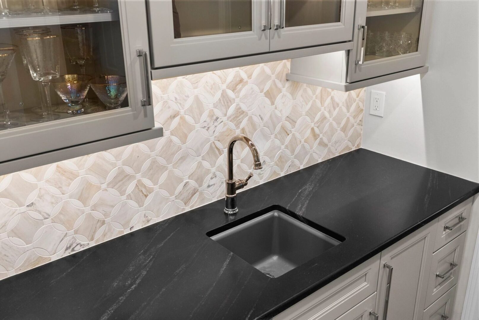 Modern kitchen with black countertop and sink.