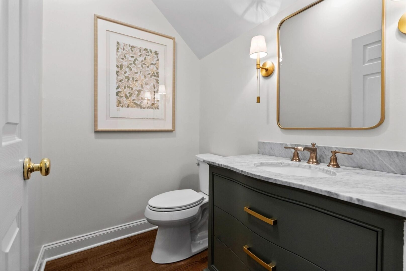 Elegant bathroom with framed art and mirror.