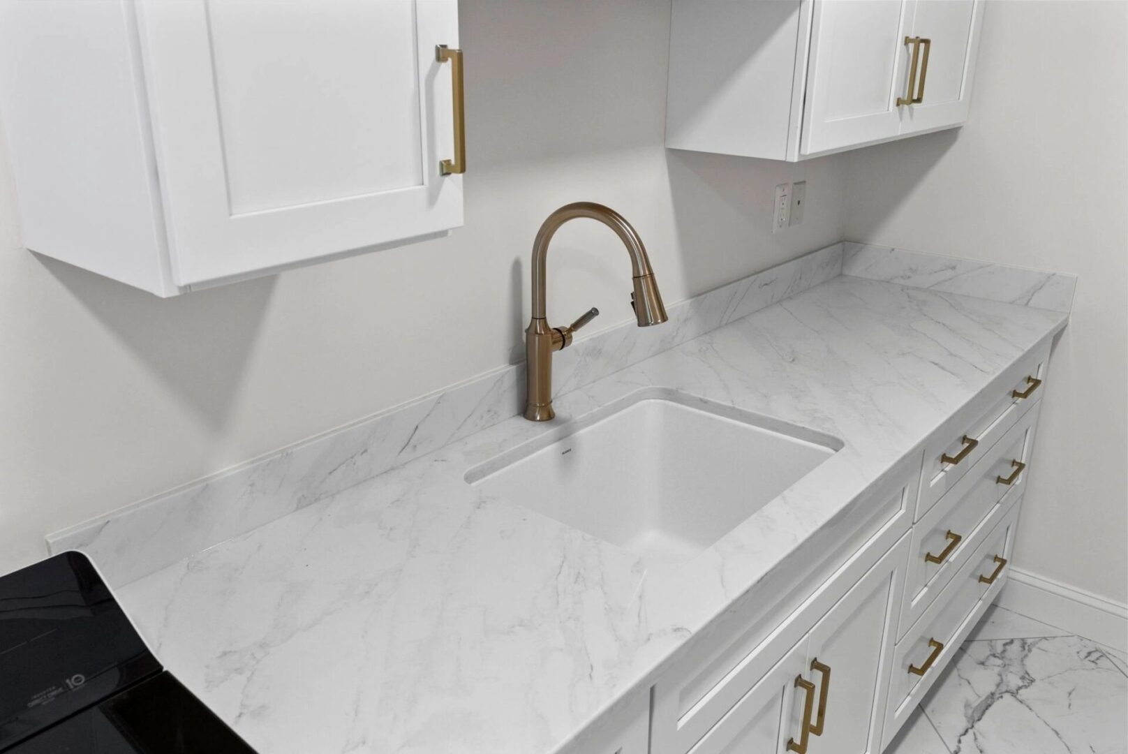 Modern kitchen with marble countertop and sink.