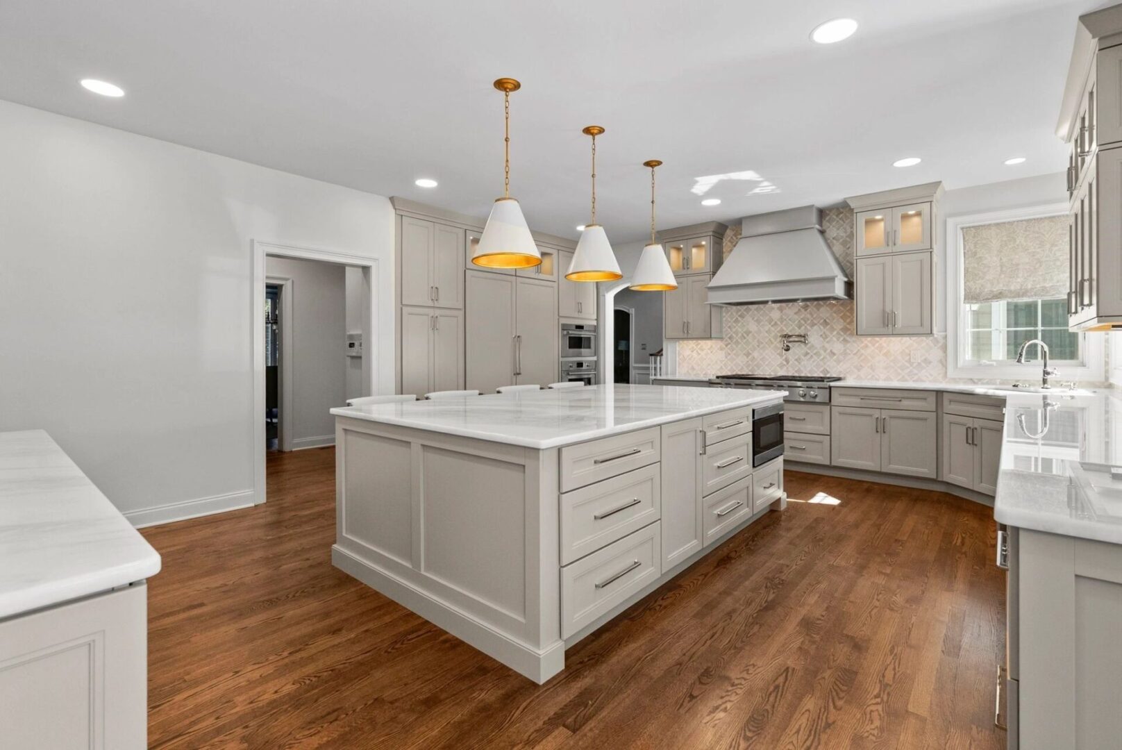 Modern kitchen with island and hardwood floors.
