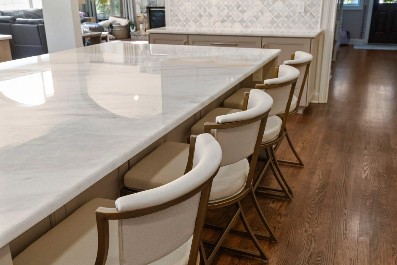 Kitchen island with chairs and wooden floor.