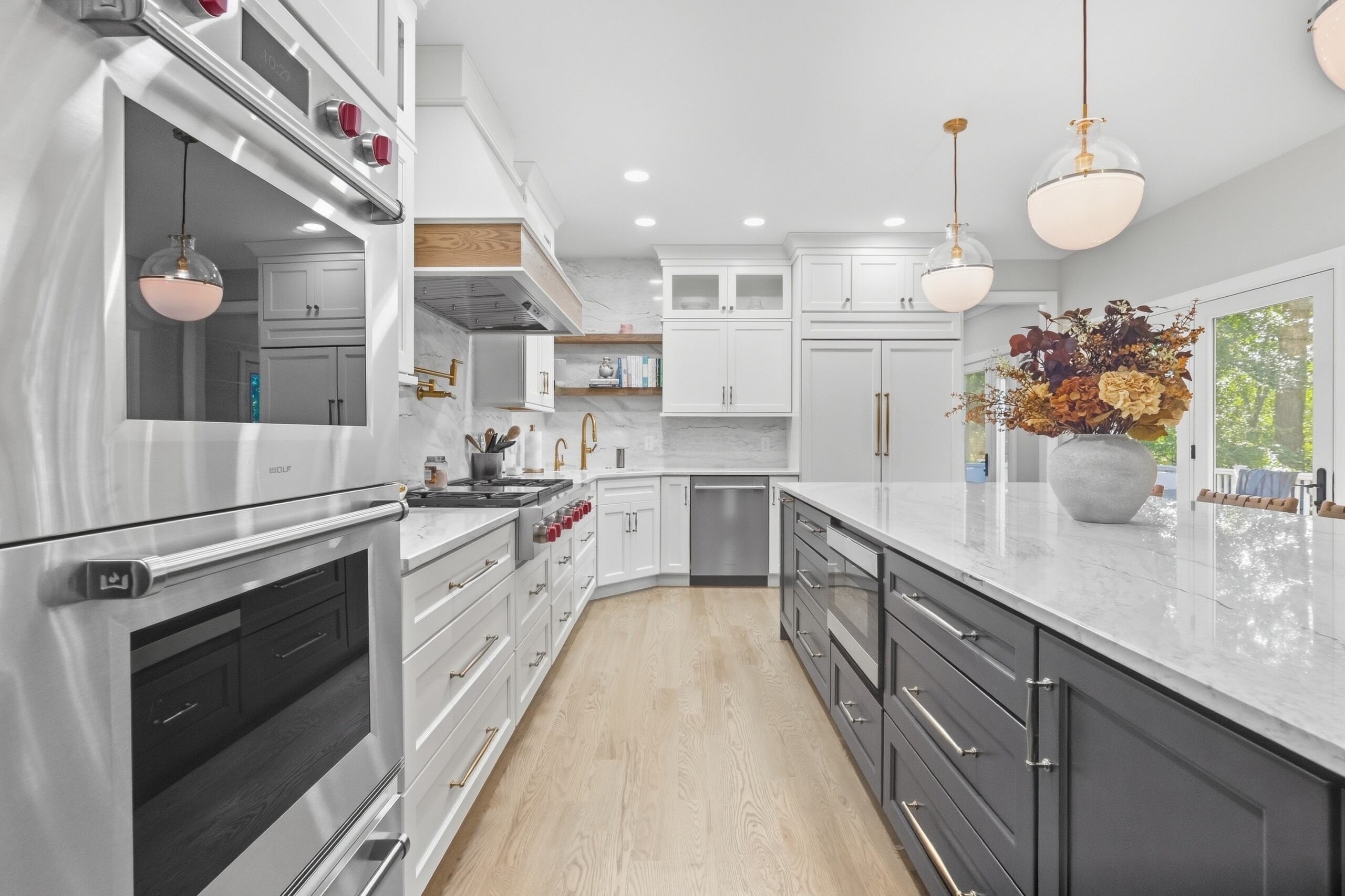 New kitchen installation completed by Reaction Exteriors featuring white cabinets, high end applianced and gold fixtures.