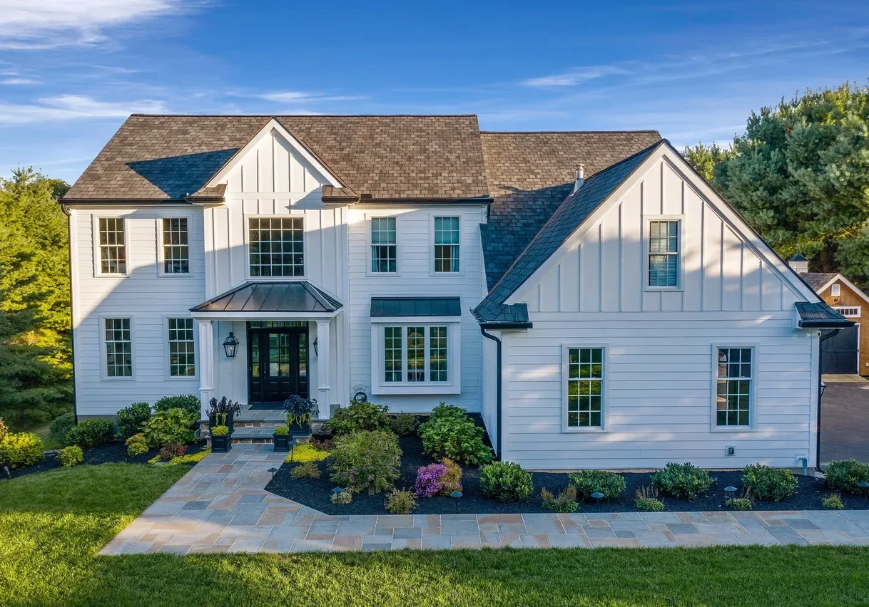 rs=w_1279,m (4) Two-story modern farmhouse with white board and batten siding, dark roof, front porch, landscaped yard, and driveway on the right.